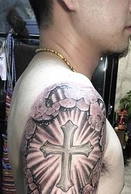 Didelės rankos labai dominuojantis kryžiaus tatuiruotės modelis