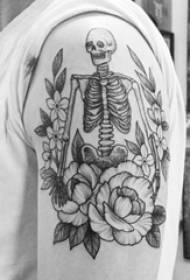 Голямата ръка на момчето върху черно сиво точка трън проста линия цвете и скелет скелет татуировка снимка