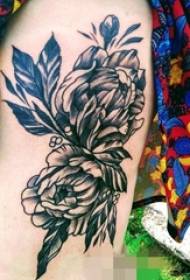 Coxa da menina na imagem de tatuagem de flor preto e branco picada de flor de truque
