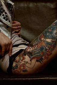 Personības tetovējums uz skaista augšstilba