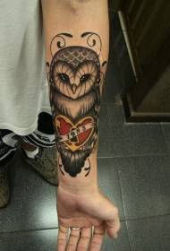 Gufo colorato con braccio femminile che tiene il modello del tatuaggio di amore