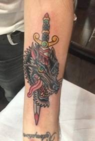 Ang tradisyonal na istilo ng lobo at dagger tattoo sa braso