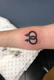 Brako de tatuaj simbolaj knabinoj sur bildo de nigra simbolo