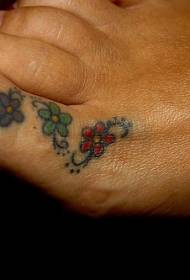 女性のつま先の色3つの小さな花のタトゥーパターン