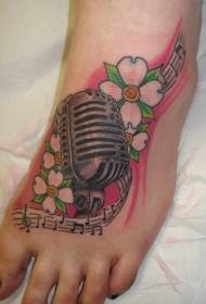 Ant kojų dažytos buko gėlės ir mikrofono tatuiruotės raštas