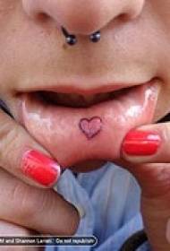 татуировка в форме сердца на внутренней губе женщины