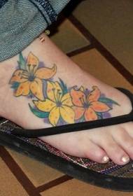 giel an orange Blummen Tattoo op weiblechen Instep