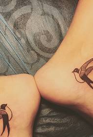 a pair of small swallow tattoo designs on the ankle