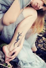 gambe della ragazza sul tatuaggio di geco