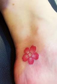 bilder på små tatueringar med körsbärsblommor som faller på den osynliga fotleden
