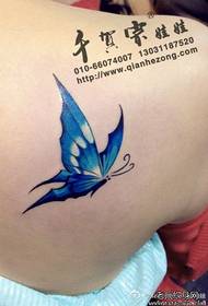 Hermosos hombros femeninos se ven patrón de tatuaje de mariposa bellamente coloreado