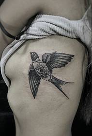 un piccolo disegno del tatuaggio rondine sul lato della vita
