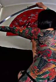 La signora piena di immagini di tatuaggi del drago diabolico a colori liberi e prepotenti