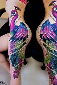 女性の横に超美しいカラフルな孔雀のタトゥーパターン