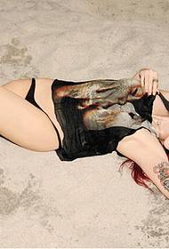 Foto di tatuaggio di bellezza straniera sexy sulla spiaggia alla fine dell'estate