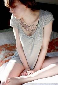 Bild av en vacker kvinna som visar en tatuering på sängen
