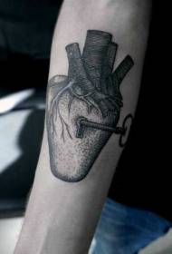 Kunci jantung hitam ditusuk lengan dengan pola kunci tato
