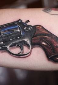 a handsome pistol tattoo on the arm
