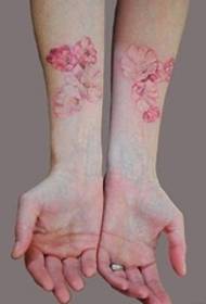 O braço da menina na tatuagem de gradiente de cor pequena imagem de tatuagem de planta fresca