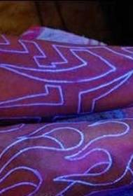 Fluorescējošs totēma tetovējums uz rokas