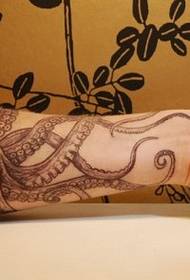 Красивая татуировка осьминога с оружием