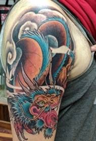 Lijepa tetovaža uzorka zmaja u cijeloj boji na velikoj ruci