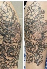 Hermosa imatge de tatuatge de flor de color gris negre al braç gran de la mà femenina