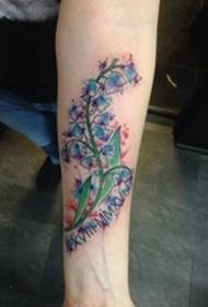 Tattoo model i bukur me lule me bojëra uji në parakrahin e dorës