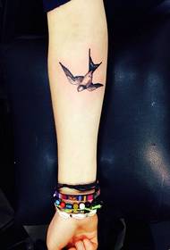 a personalized swallow tattoo on the arm
