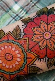 Tattoo pictures of flowers on two red arms