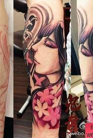 Hermosa chica do tatuaje en flor de cereixa cos brazos