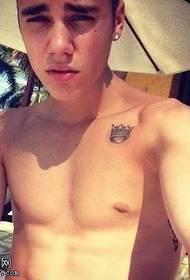 Justin Bieber mostra perna rezando tatuagem padrão