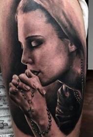 Jongens arm op zwart grijs punt doorn vaardigheid kruis en portret tattoo foto