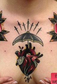 Dievča vpredu na hrudi klasického srdca starej školy s ružovým vzorom na tetovanie