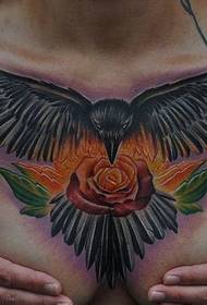 Грудь девушки, красивый ворон и роза с татуировкой