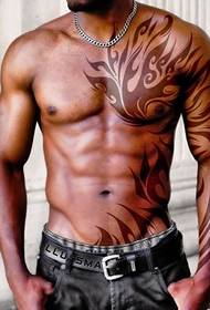 Un omu musculusu robusto è un bellu mudellu di tatuaggi di totem tribale