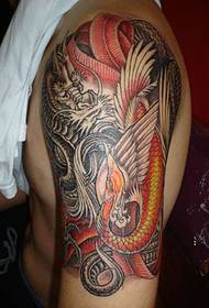 Dragon a Phoenix Tattoo Muster um Aarm vun enger Hand vun engem Mann