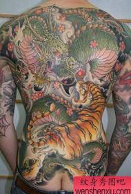Male back with super cool domineering full back dragon and tiger battle tattoo pattern