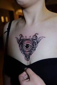 Il tatuaggio del tatuaggio con gli occhi geometrici sulla scollatura è molto sexy