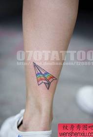 Girl's leg with a paper plane tattoo pattern
