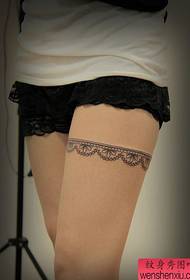 Un modello di tatuaggio in pizzo semplice e delicato sulle gambe della ragazza