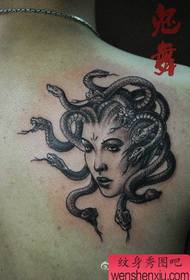 Ti gason ak yon nwa gri meduz tatoo sou zepòl la