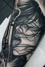 Čierna biela žena s tetovaním na pištoľ
