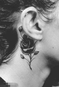 Orecchio femminile dietro schizzo nero che punge la bella foto rosa del tatuaggio