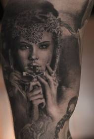 Modello femminile realistico grigio nero che tiene il modello del tatuaggio dell'incrocio