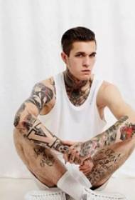 I tatuaggi di bel ragazzo mostrano l'immagine di uomini alla moda