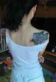 Foto di tatuaggio rosa viola sotto la spalla di una ragazza