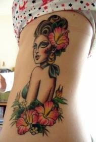 Immagine di tatuaggio di colore della donna e fiore di ibisco sul fianco laterale