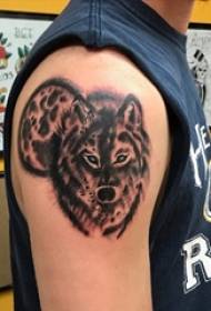 Brațul băiatului pe poza de tatuaj de lup mic cu animale negre
