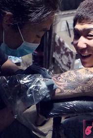 Ang tattoo artist ay nagbibigay sa mga customer ng isang seryosong proseso ng tattoo